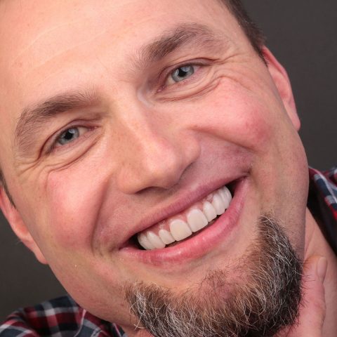 Uśmiechnięty mężczyzna Dr Szadowski Implantologia i Stomatologia Estetyczna